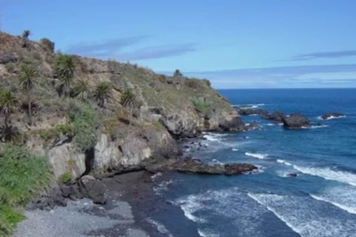 On Spain's Castro Beach, Black Sands And Waterfalls Beckon Adventurers